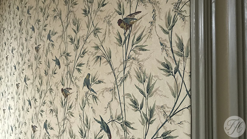 Detail van behang met klassieke uitstraling op authentiek betengelde ondergrond in monumentaal pand